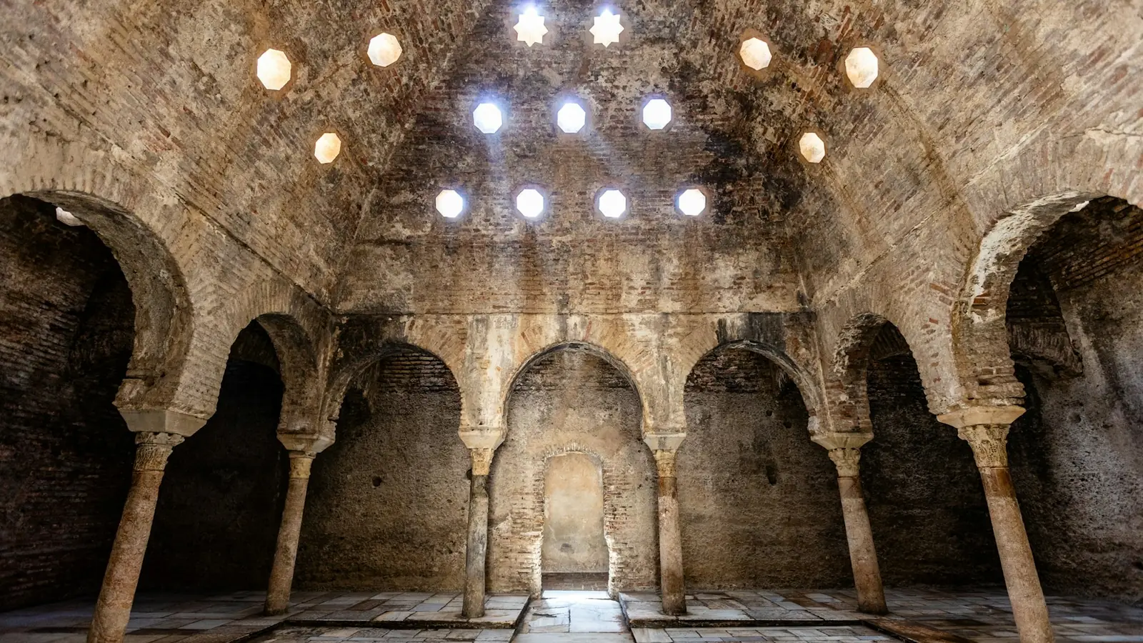 Каменные своды и звёздчатые окна в куполе старинной бани